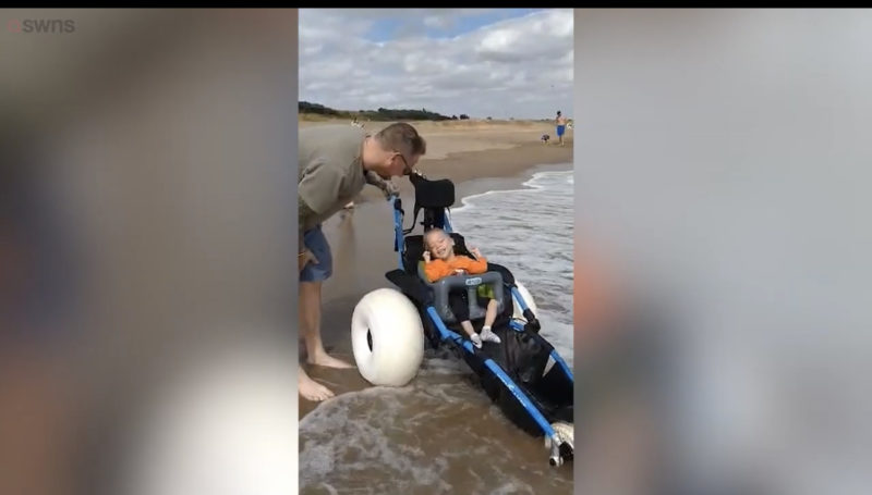Un niño discapacitado rompe a llorar después de que desconocidos le construyeran una silla de ruedas que le permite jugar en el océano.