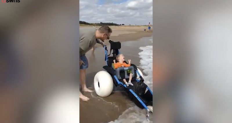 Un niño discapacitado rompe a llorar después de que desconocidos le construyeran una silla de ruedas que le permite jugar en el océano.