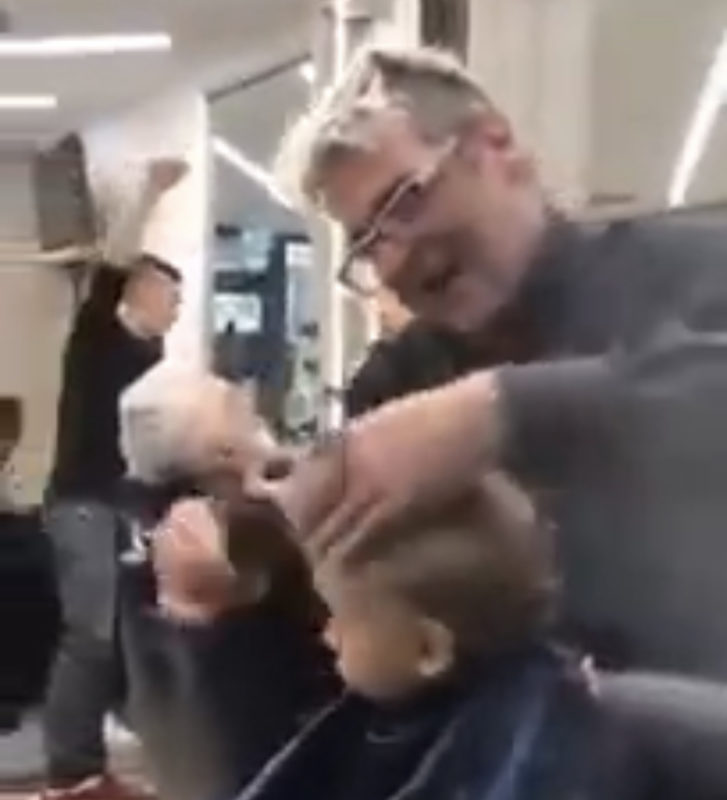 Barberos italianos comienzan a cantar para distraer a un niño asustado durante un corte de pelo.