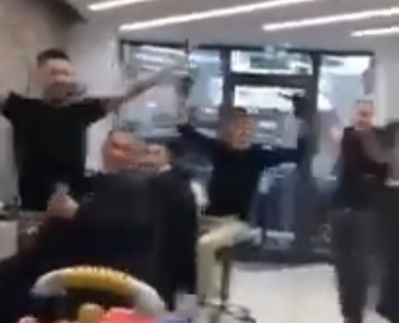 Barberos italianos comienzan a cantar para distraer a un niño asustado durante un corte de pelo.