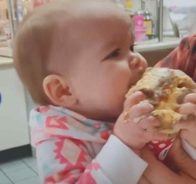 Después de dar su primer lametazo al helado, el bebé se sorprende.