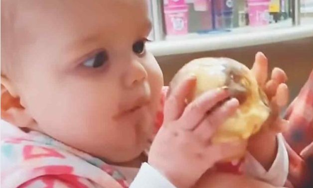 Después de dar su primer lametazo al helado, el bebé se sorprende.