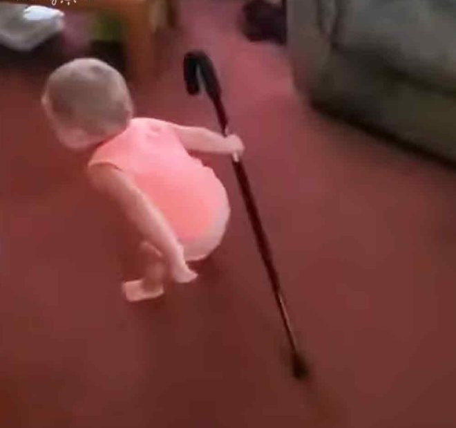 Una preciosa niña pequeña imita adorablemente el caminar de su abuelo.