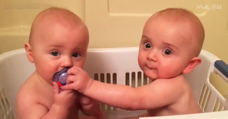 Los adorables gemelos se divierten con sus chupetes.
