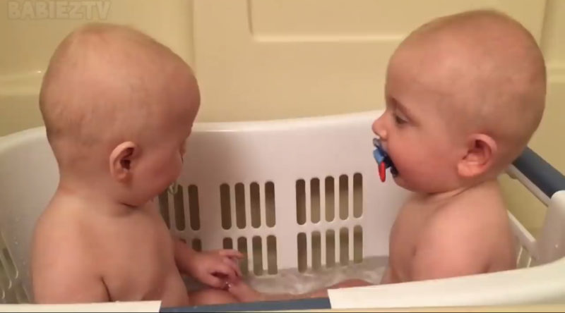 Los adorables gemelos se divierten con sus chupetes.