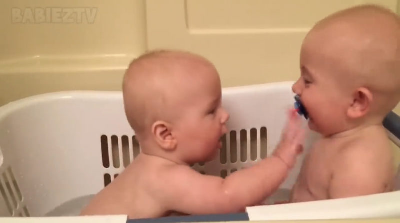 Los adorables gemelos se divierten con sus chupetes.