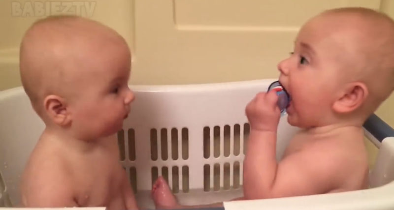 Los adorables gemelos se divierten con sus chupetes.