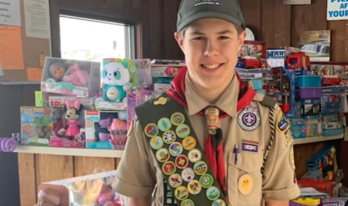 Un joven miembro de los Scouts cumple su promesa de "Ayudar a los demás" con sincera amabilidad.