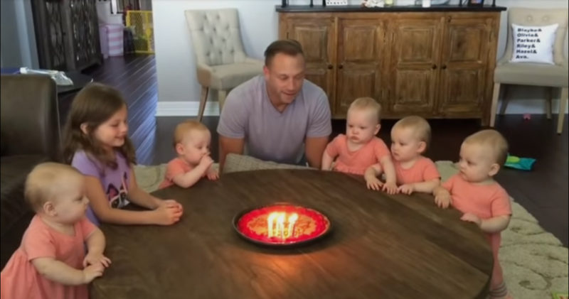Las hijas desean feliz cumpleaños a su papá. Observa a los bebés mientras sopla las velas.