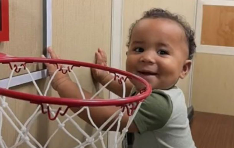Pequeño espectador de un juego de baloncesto. La razón por la que está allí te sorprenderá.