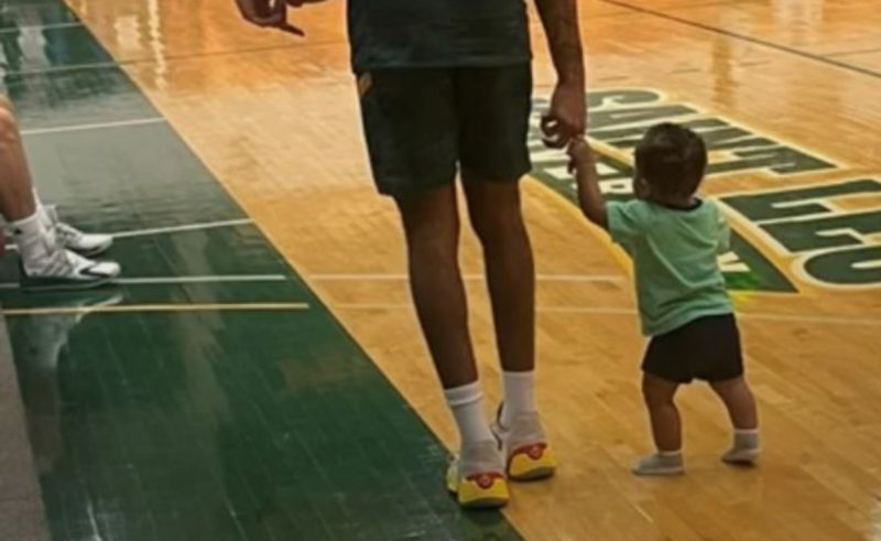 Pequeño espectador de un juego de baloncesto. La razón por la que está allí te sorprenderá.