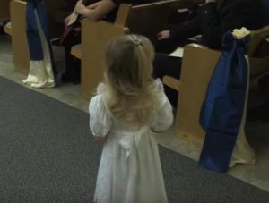 Esta pequeña florista emocionada quedó atrapada en el pasillo y no podía caminar. La forma en que el padrino vino a su rescate es muy divertida...
