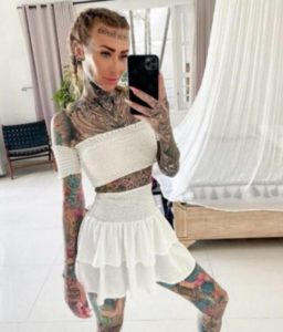 Desvelando la apariencia natural: Observa la transformación de una mujer, con un 95% de tatuajes, al revelar su aspect