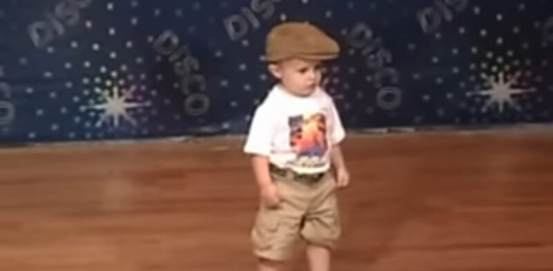 Un niño pequeño espera en el escenario para bailar: cuando comienza la música, el público se vuelve loco